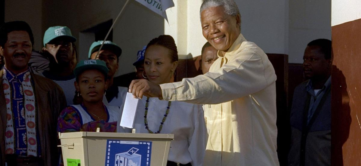 Nelson M和ela drops his ballot into a voting box